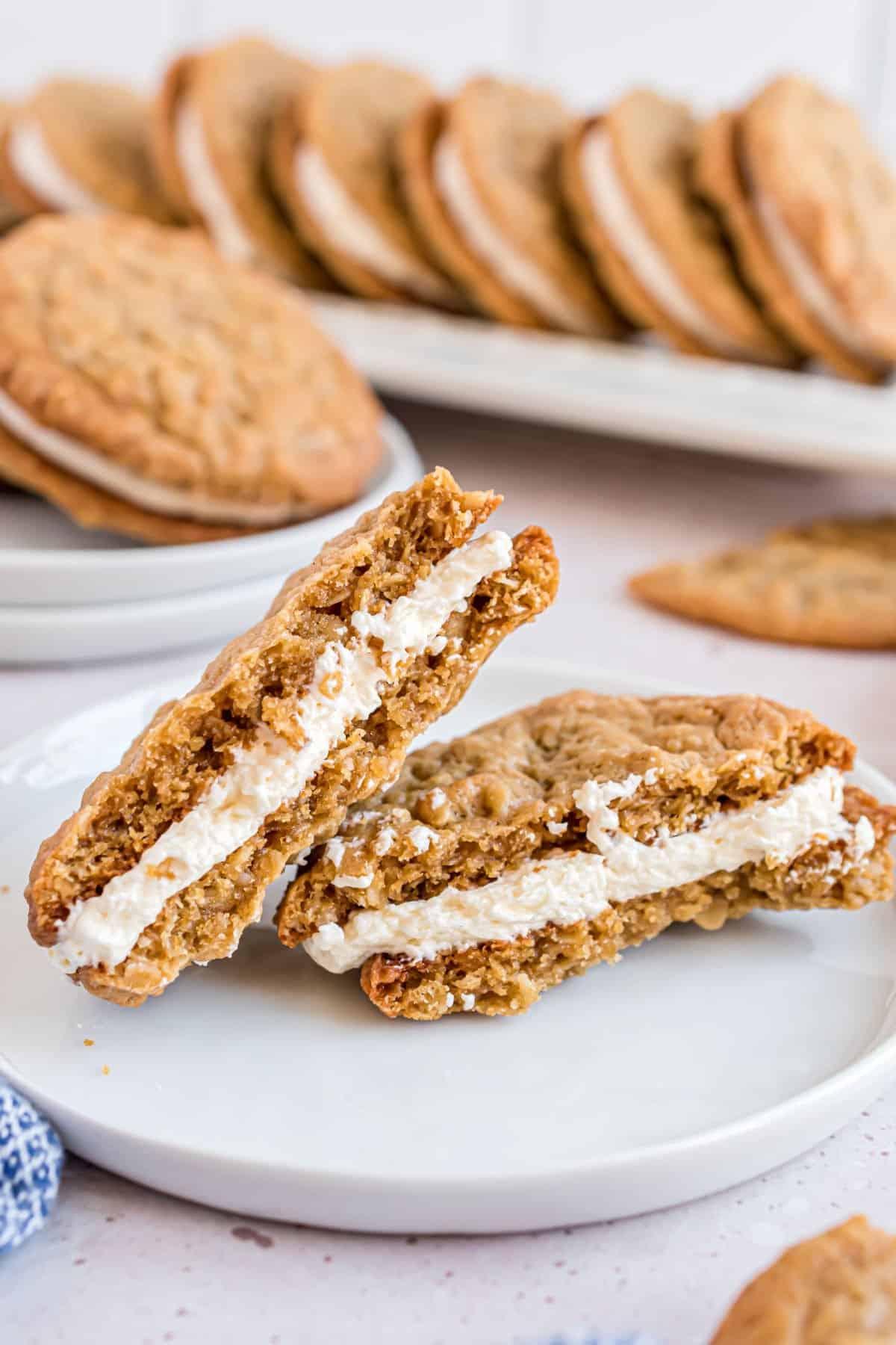 Oatmeal cream pie broken in half on a white plate.