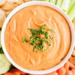 Roasted red pepper hummus in a white serving bowl.