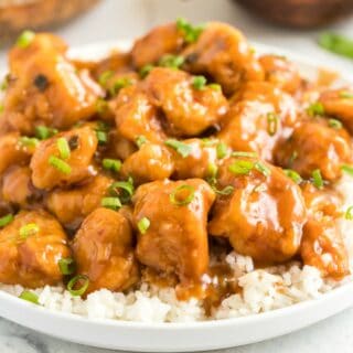 Orange chicken with glaze over white rice.