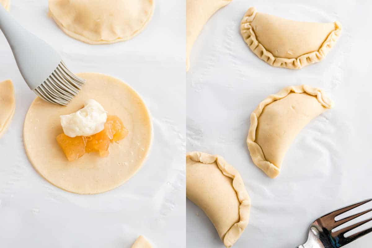 Round dough with filling topped by cream; these apple empanadas showcase folded and crimped pastries on a white surface, with a fork and brush visible.