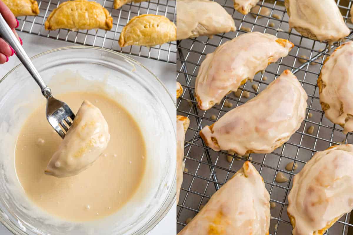 Hand dipping baked apple empanada in glaze, with glazed apple empanadas drying on a wire rack beside it.