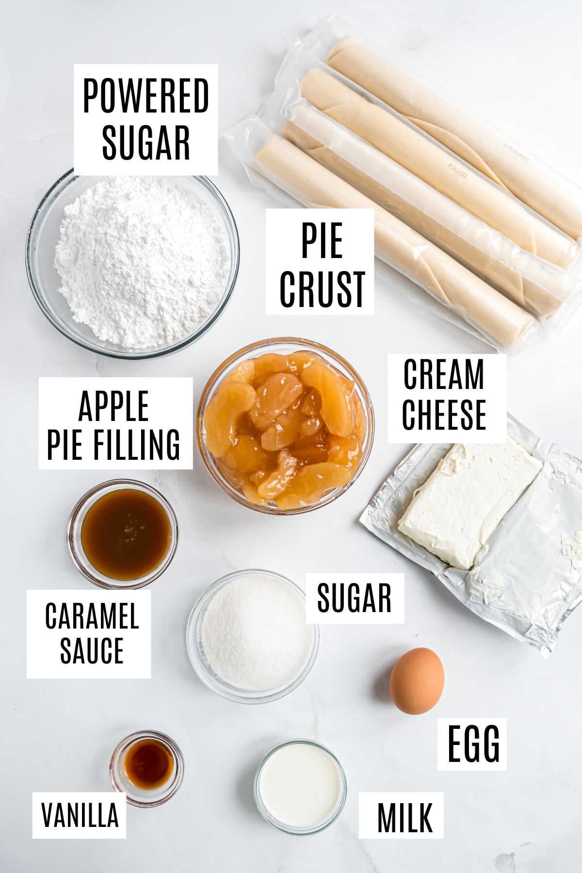 Ingredients for apple pie cheesecake: pie crust, apple filling—just like in classic apple empanadas—cream cheese, sugars, egg, milk, vanilla, caramel sauce.