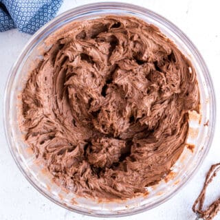 Chocolate buttercream frosting in a glass bowl.