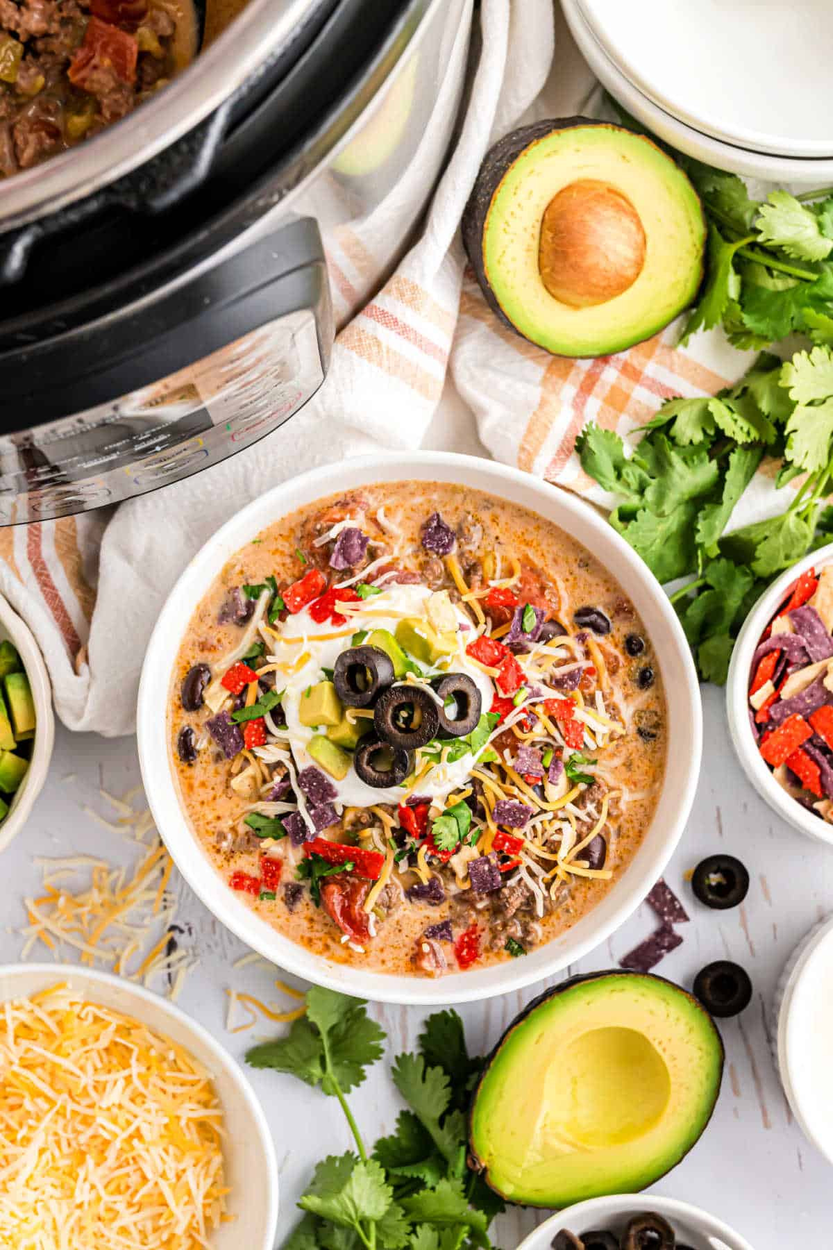 Taco soup served in a white bowl with toppings.