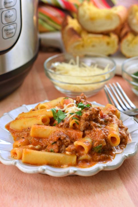 Plate of ziti made in the instant pot with parmesan cheese and garlic bread