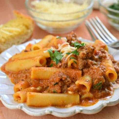 Ziti on a white plate and garnished with parmesan cheese.