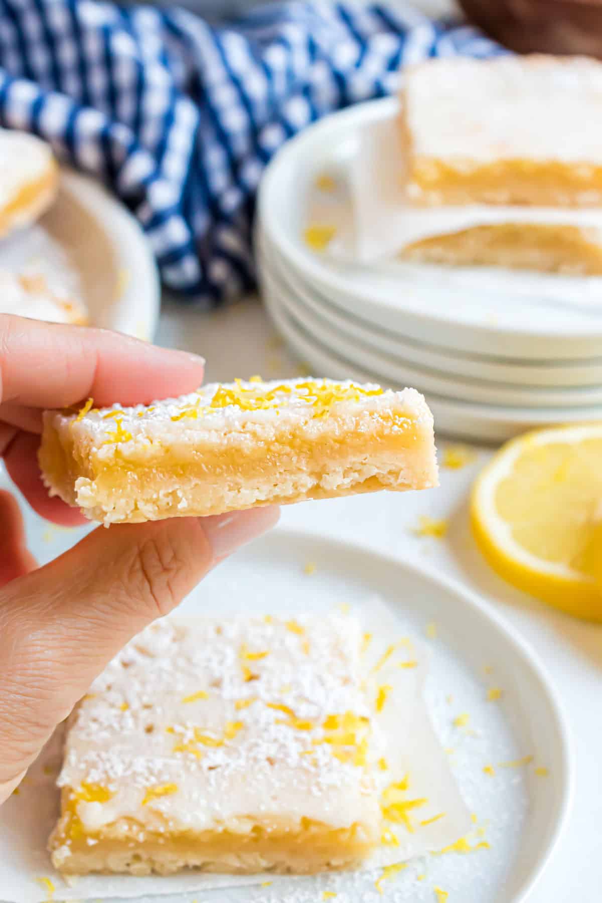 Lemon bar being held before taking a bite.