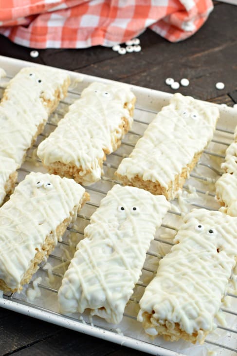 WIre rack with mummy decorated rice krispie treats for halloween.