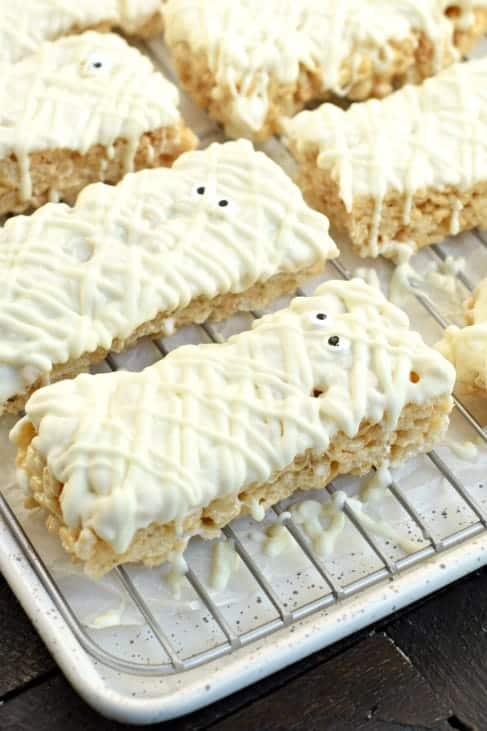 Wire rack filled with Halloween rice krispie treats decorated as mummies.