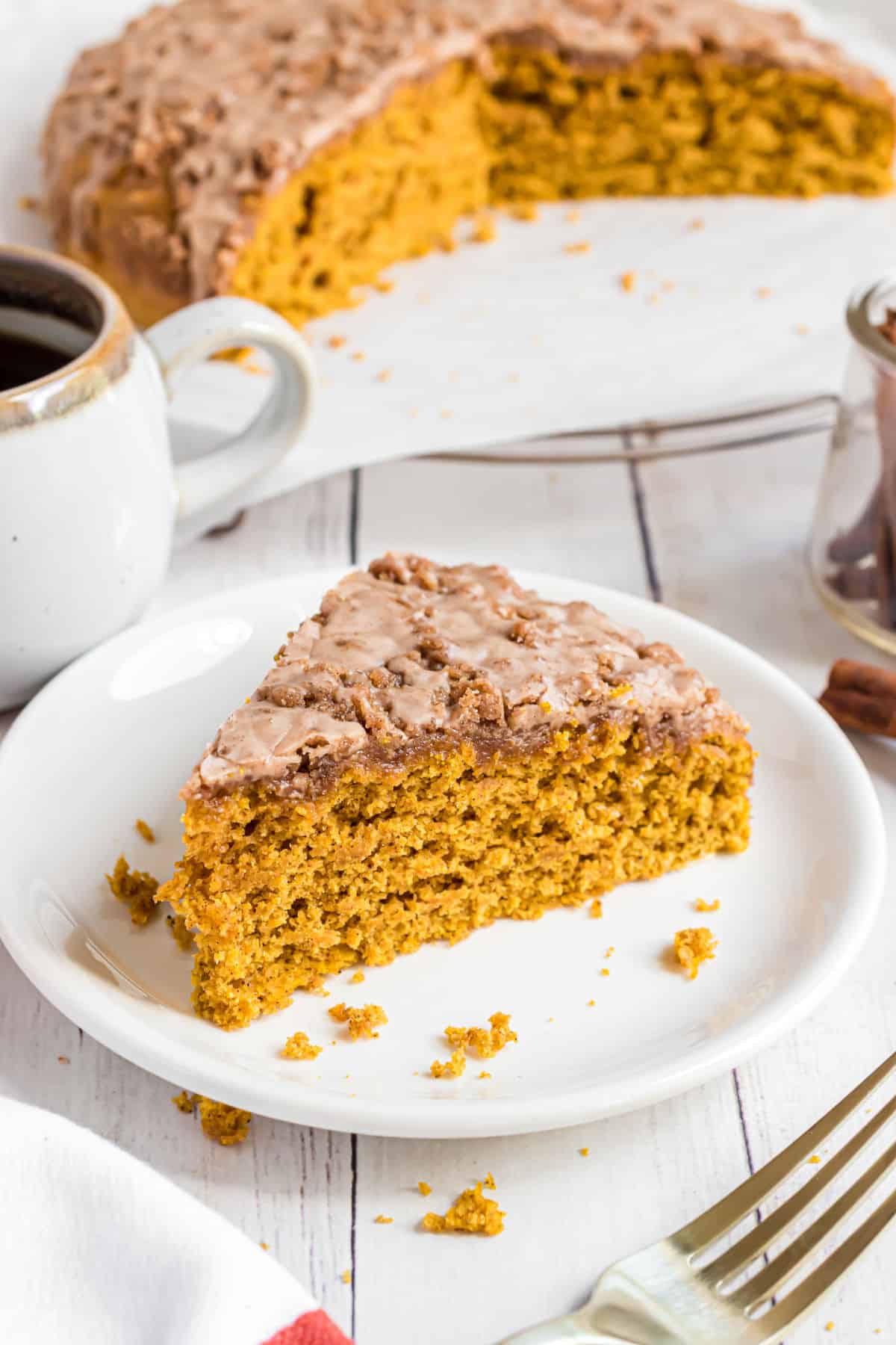 Slice of pumpkin coffee cake served on a white plate.