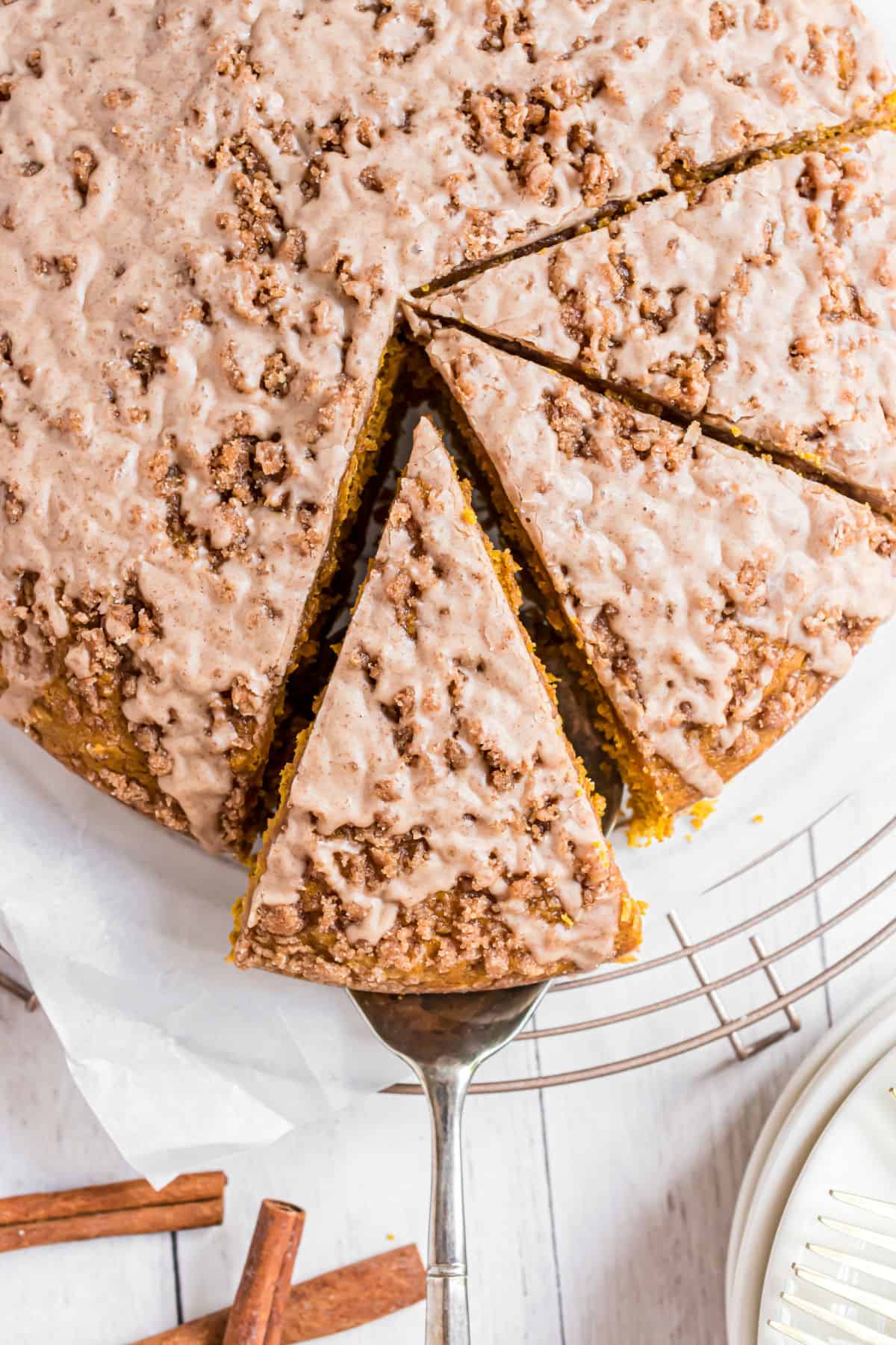 Slice of pumpkin coffee cake being removed from cake plate.