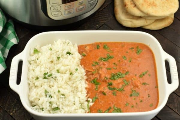 Instant Pot Butter Chicken served with cilantro lime rice and naan bread.