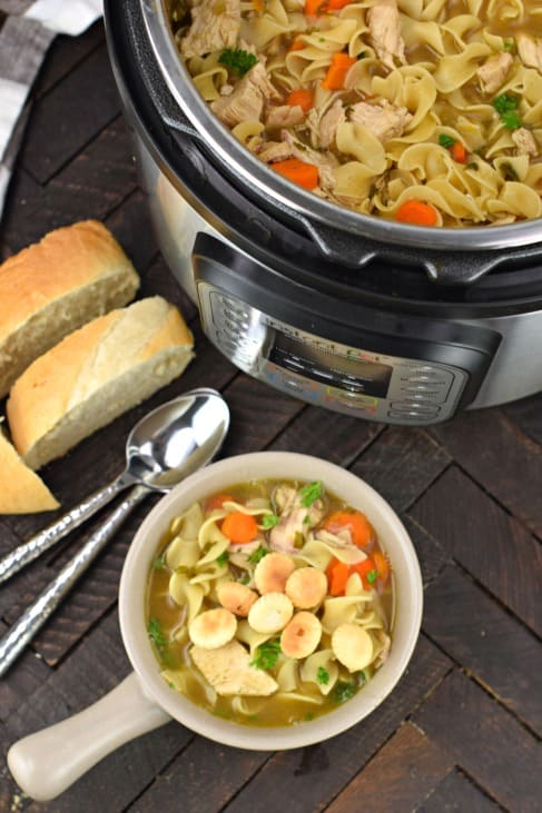 Bowl of chicken noodle soup being served from the instant pot.