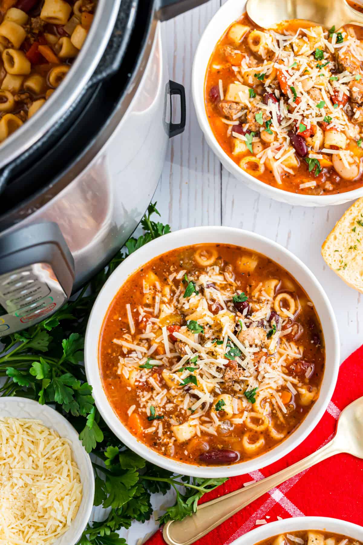 Bowl of pasta e fagioli soup topped with cheese and parsley.