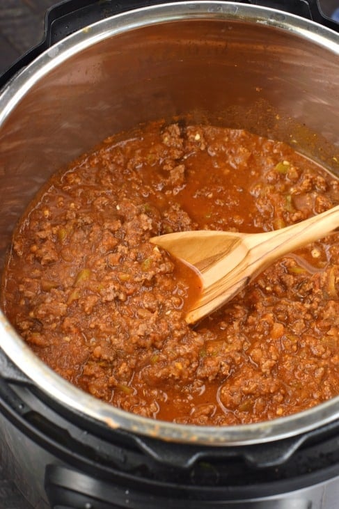 Instant pot with sloppy joes and a wooden spoon.
