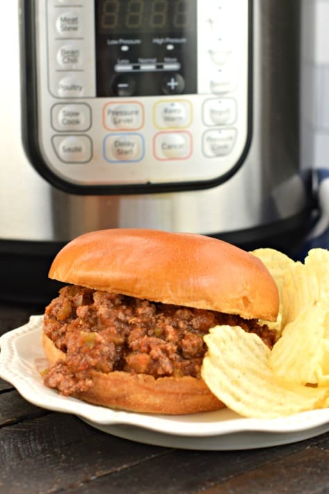 Bun with sloppy joes and potato chips. Instant Pot in background.