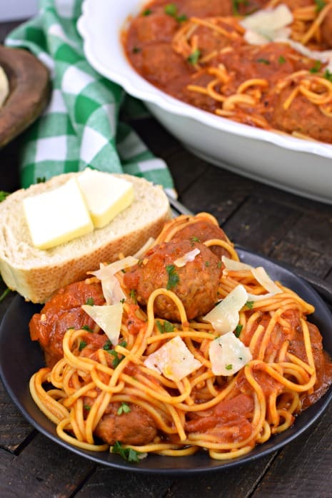 Plate with spaghetti, meatballs, and french bread.