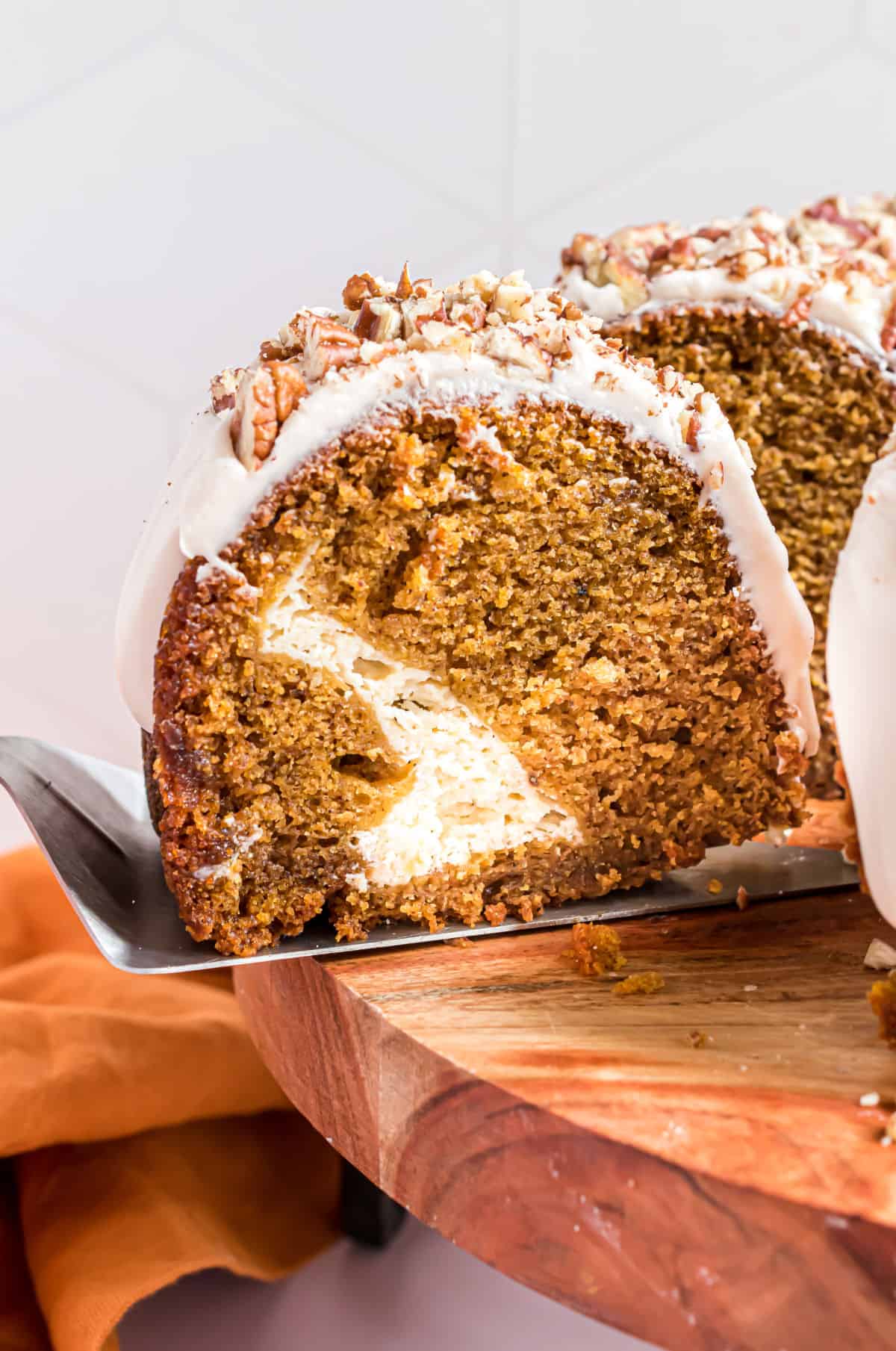 Slice of pumpkin bundt cake revealing a cheesecake swirl.