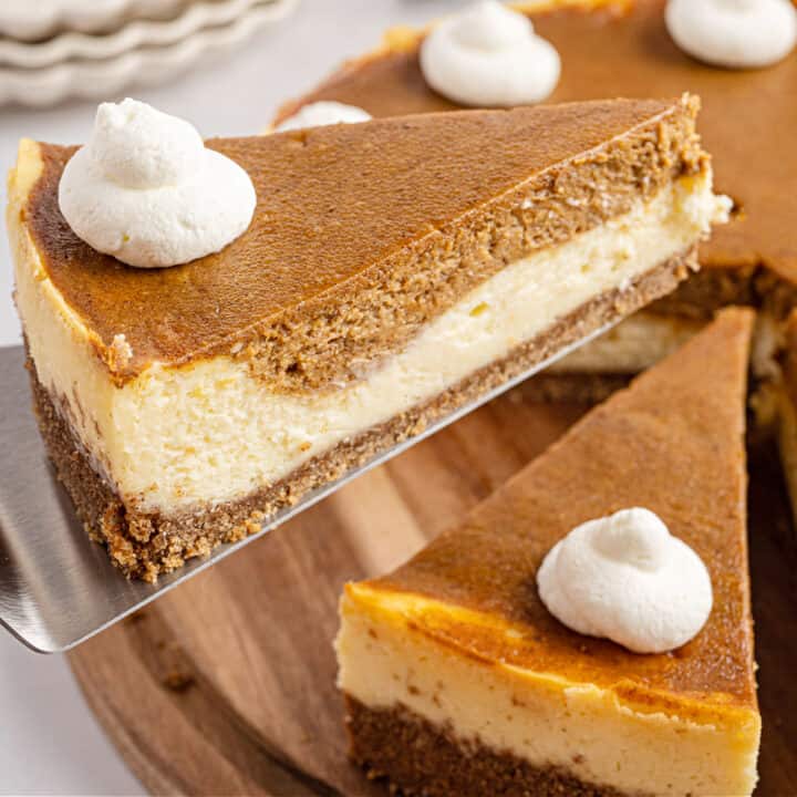 Slice of pumpkin cheesecake being lifted off pan.