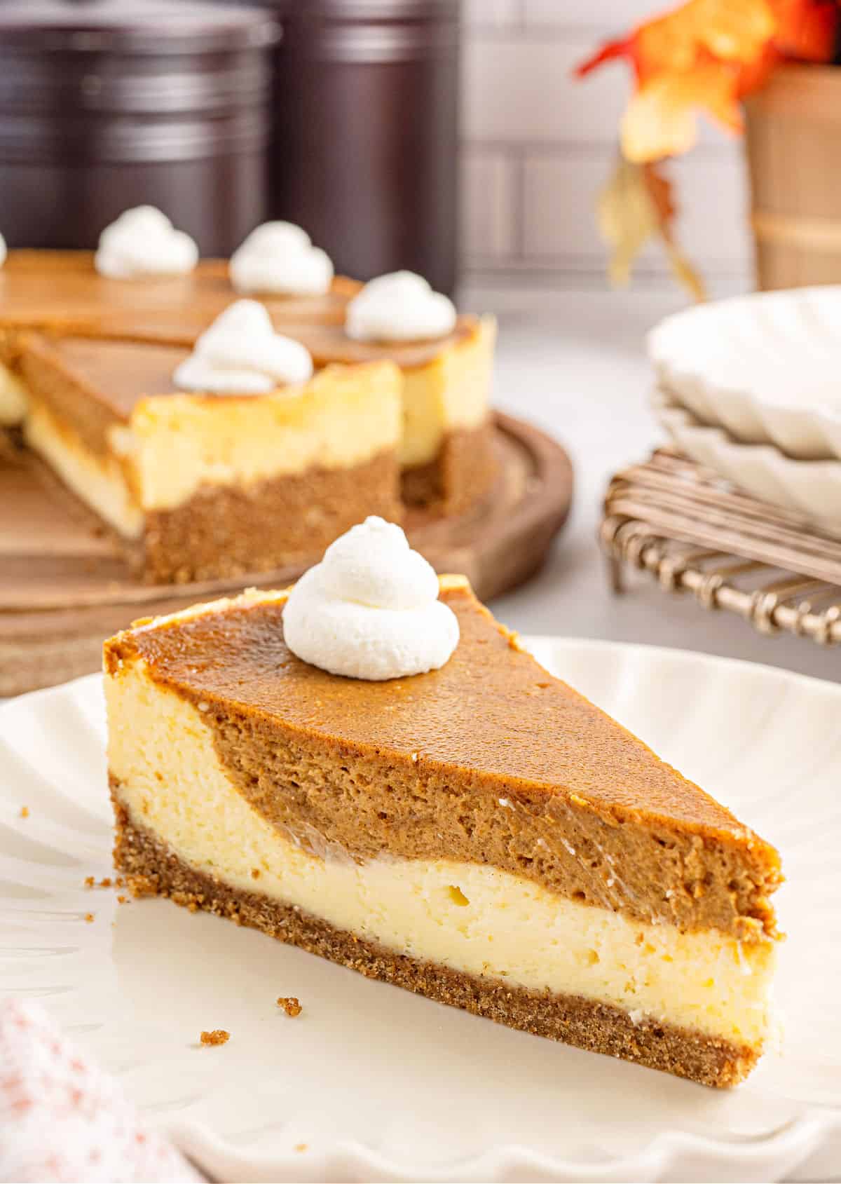 Slice of cheesecake with pumpkin pie swirled throughout.