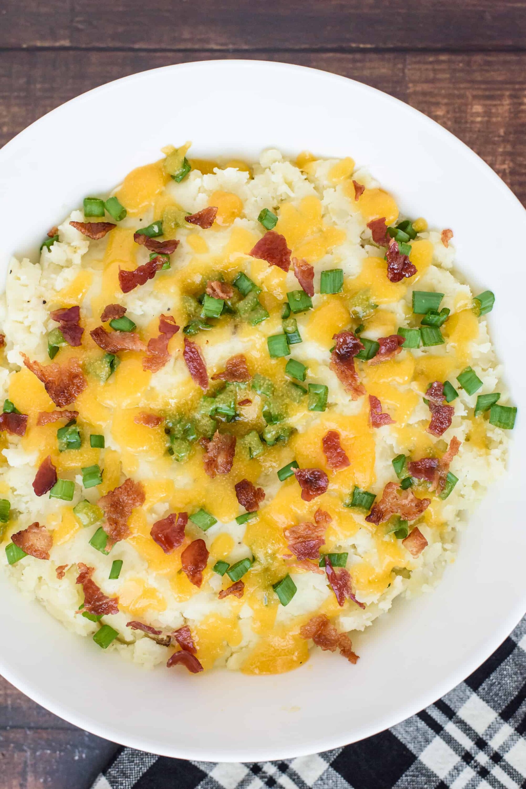 Mashed potatoes served with cheese, onions, and bacon.