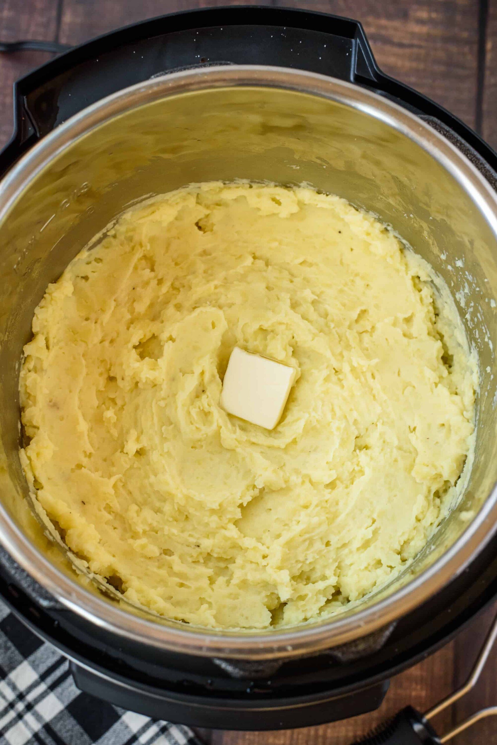 Mashed potatoes with a dollop of butter in the pressure cooker.