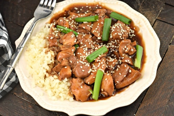 Mongolian chicken garnished with sesame seeds and served with rice.