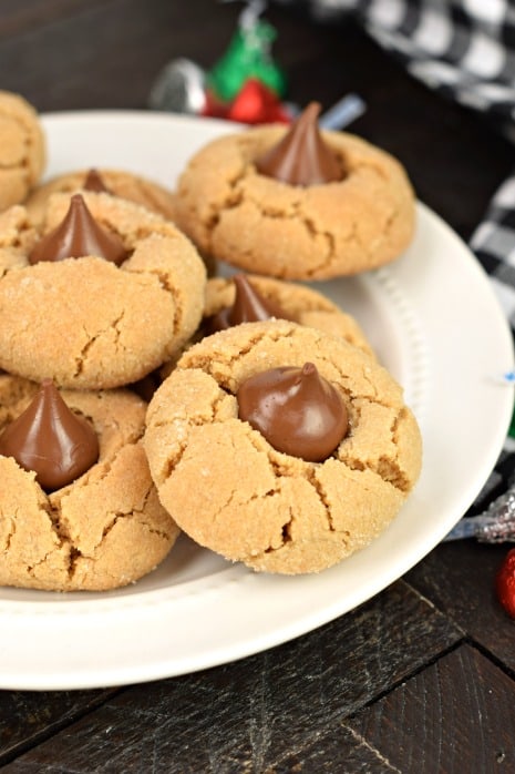 White plate with hershey kiss topped peanut butter cookies.