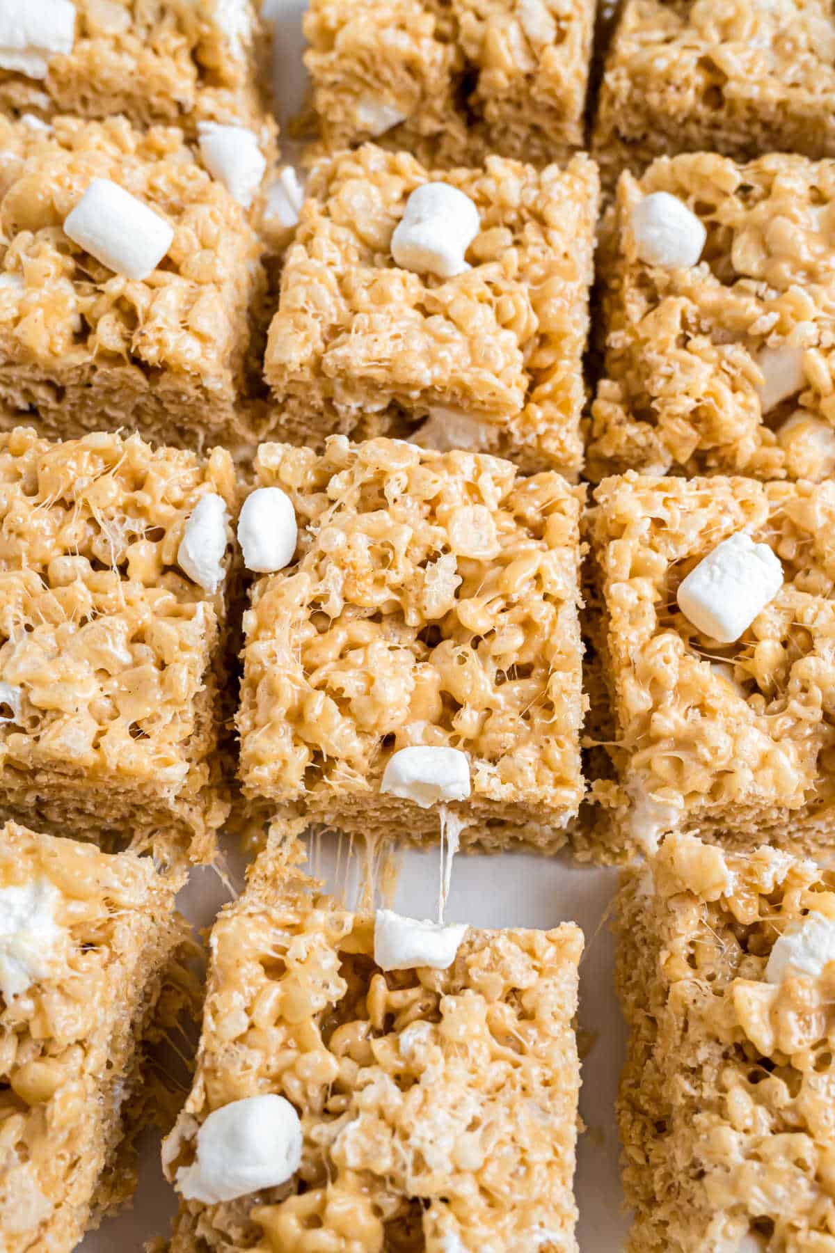 Close-up of peanut butter Rice Krispie treats cut into squares, with visible marshmallows on top.