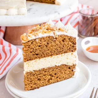 Pumpkin Cheesecake Cake: two layers of delicious pumpkin cake with a creamy cheesecake center. Frosted with cream cheese frosting! You'll love this holiday dessert.