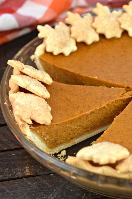Pumpkin pie with one slice cut.
