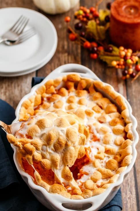 Oval baking dish with sweet potato casserole topped with toasted marshmallows.