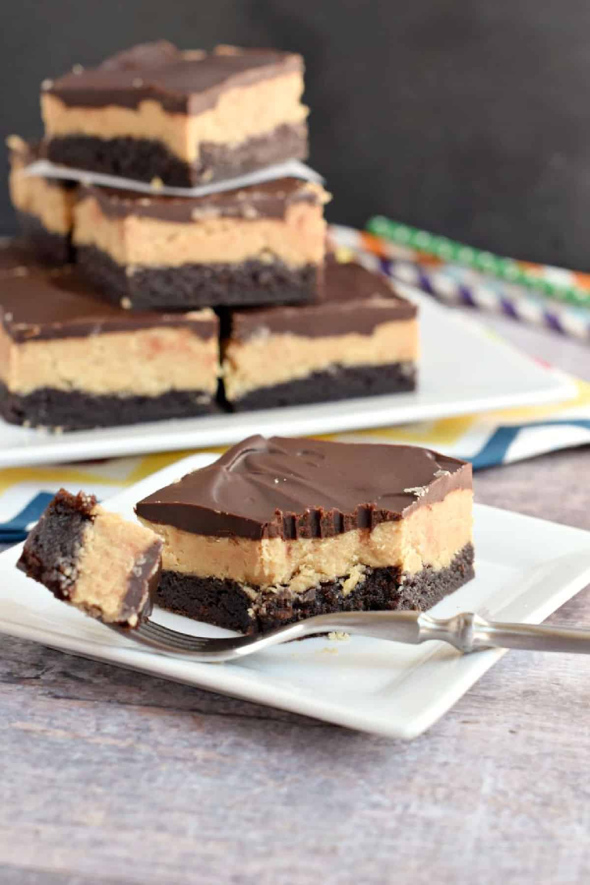 Peanut butter topped brownie on a plate with a fork and a bite taken out.