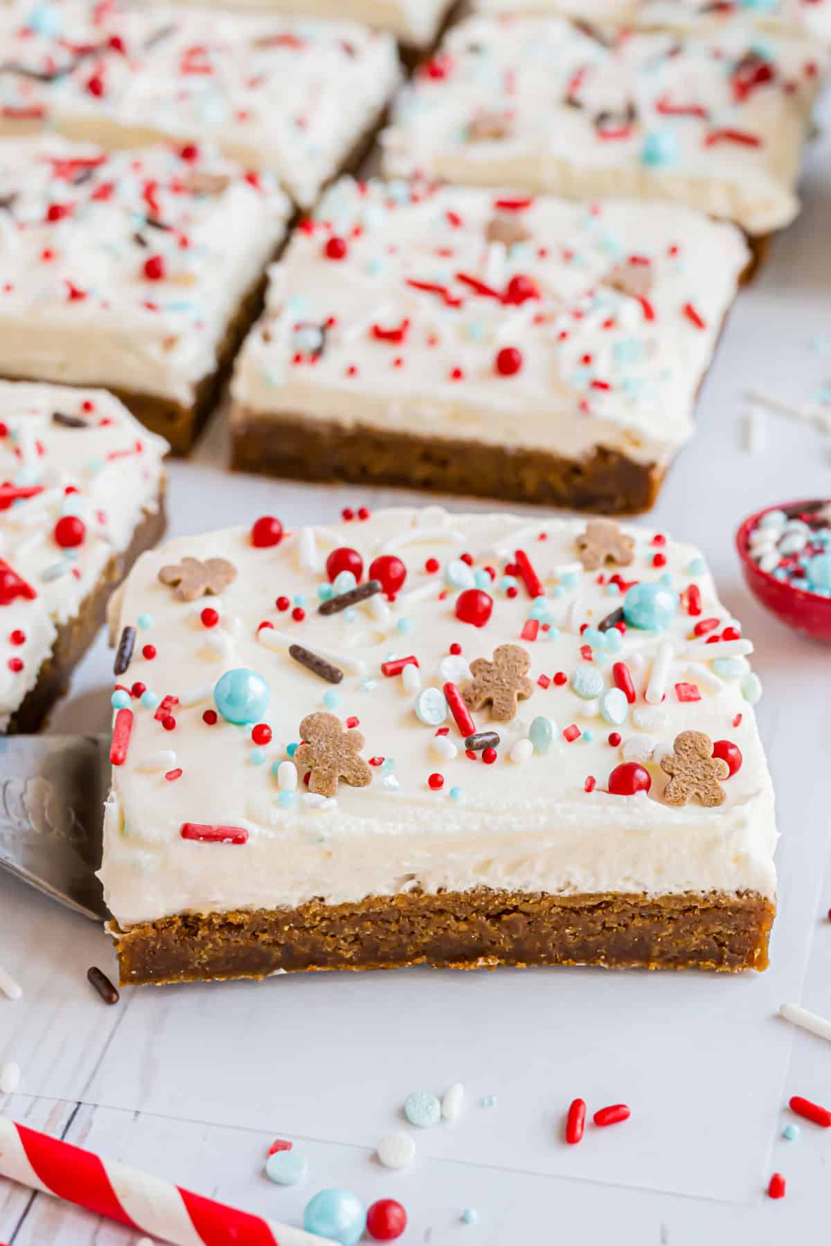 Gingerbread cookie bars topped with cream cheese frosting and sprinkles.