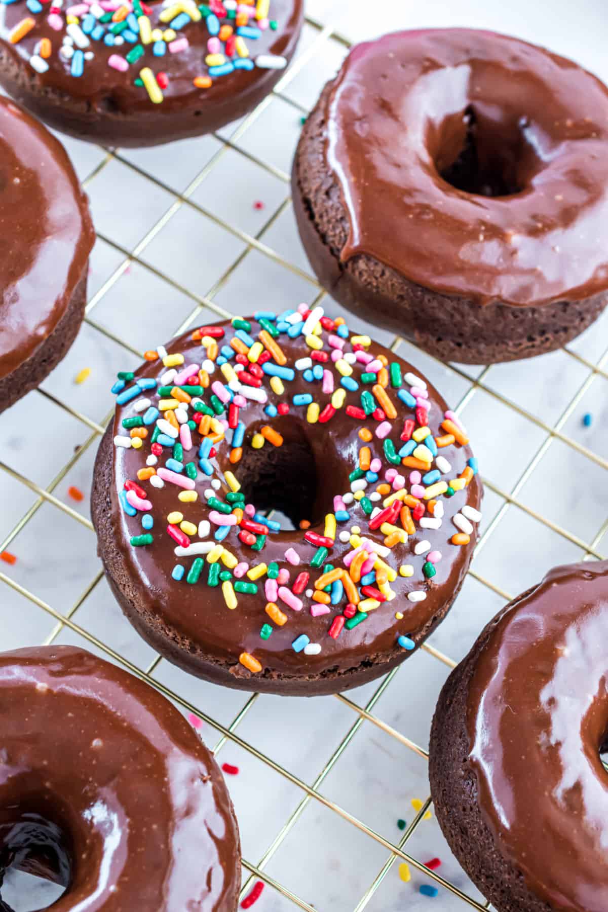 Baked chocolate donuts with chocolate glaze and sprinkles.