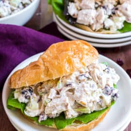 Chicken salad on a croissant with a bed of lettuce.