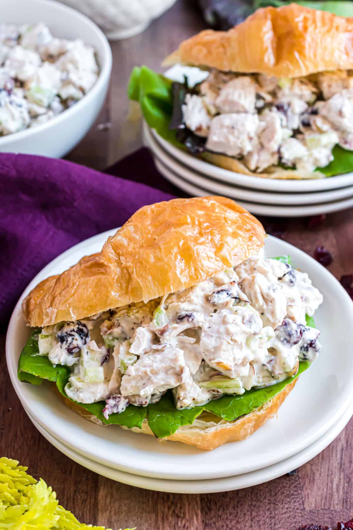 Chicken salad on a croissant with a bed of lettuce.