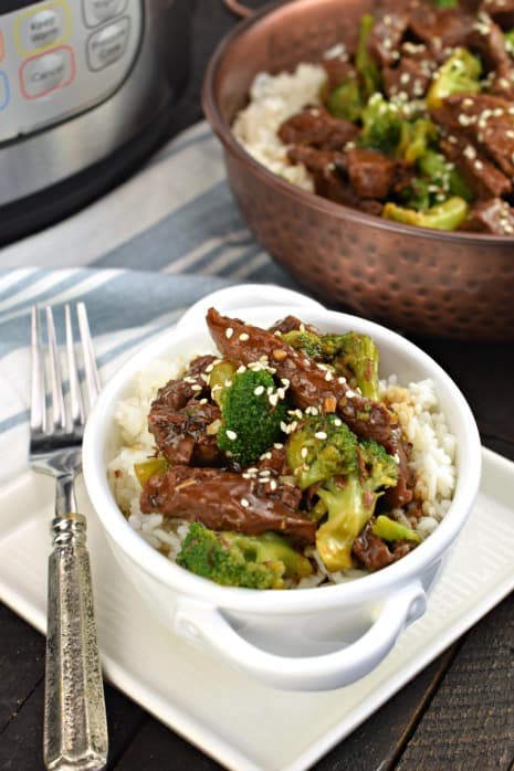 White bowl with rice topped with beef broccoli.