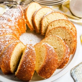 Bundt cake cut into slices on a white plate.