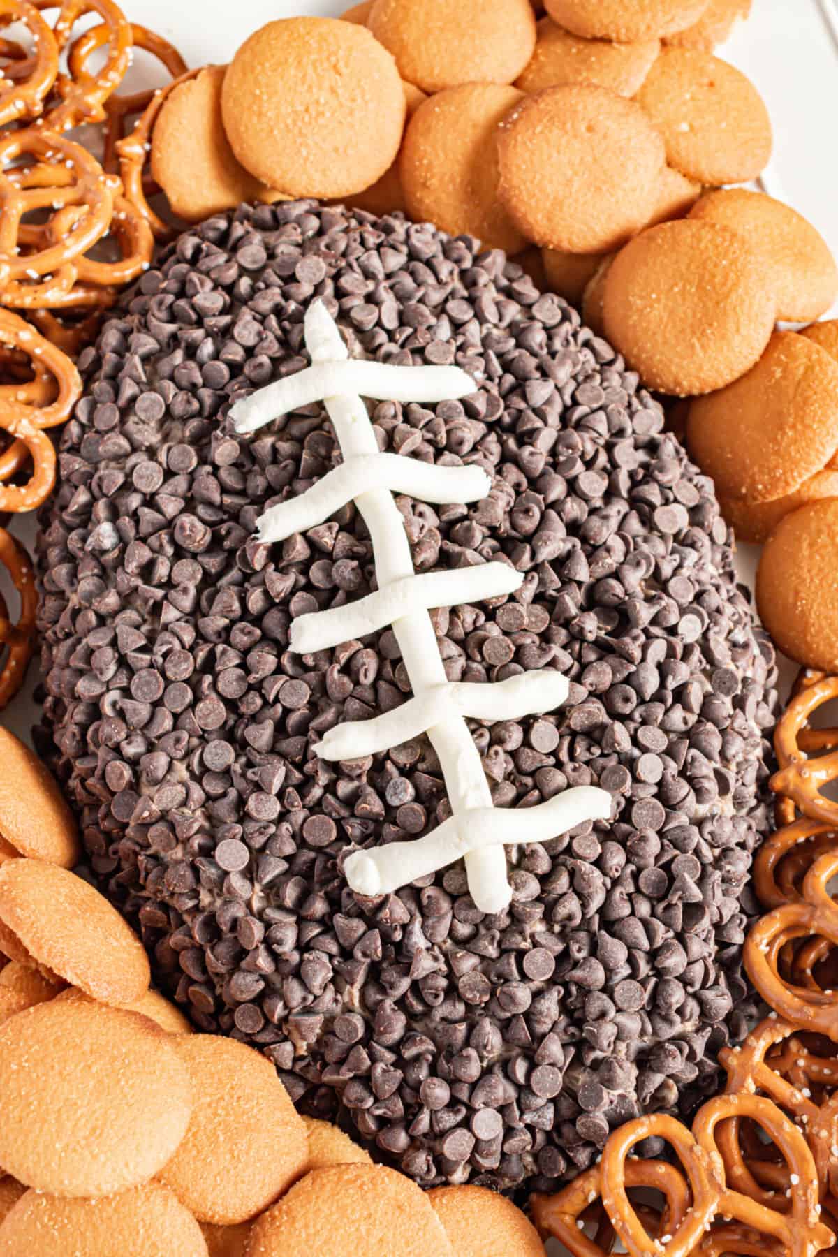 Football shaped oreo cheese ball with nilla wafers and pretzels.