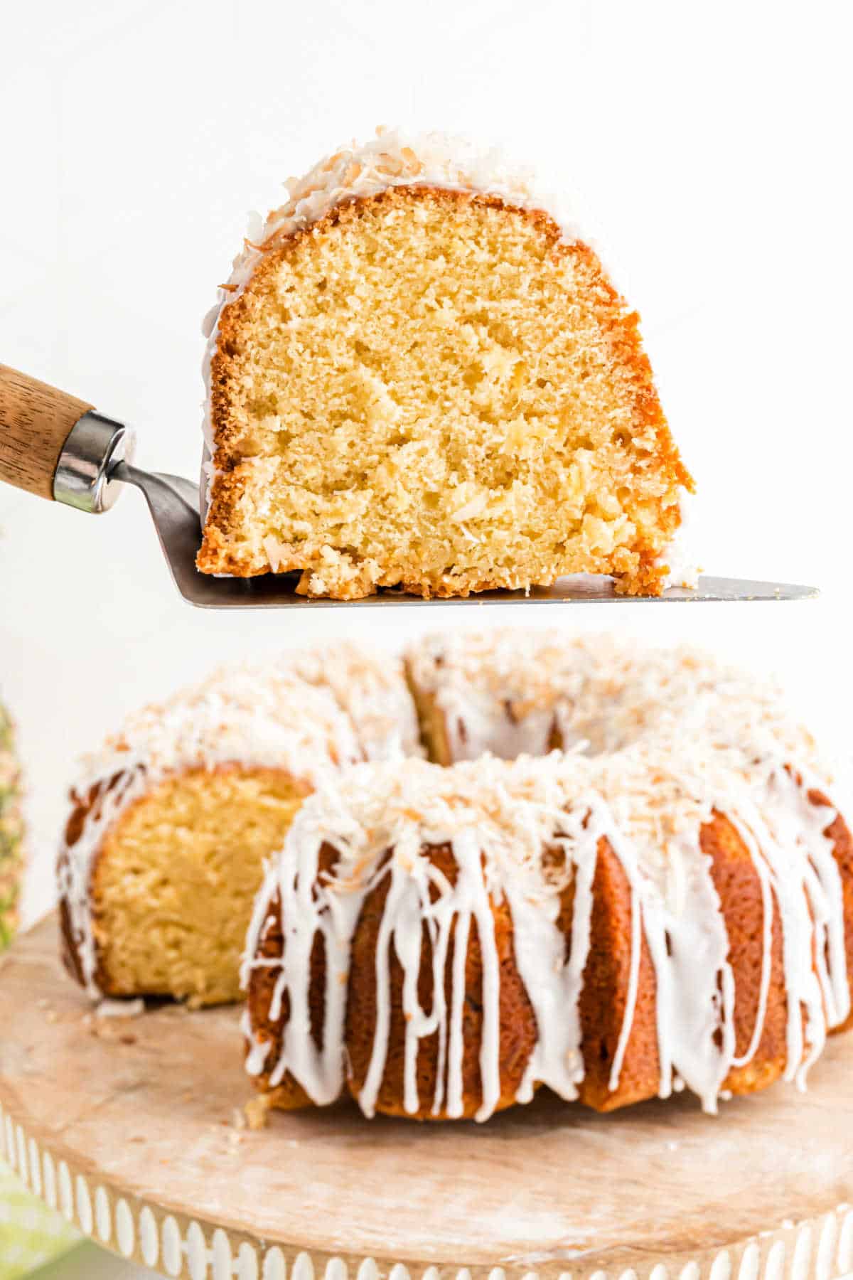 Slice of pineapple pound cake being lifted with a spatula.