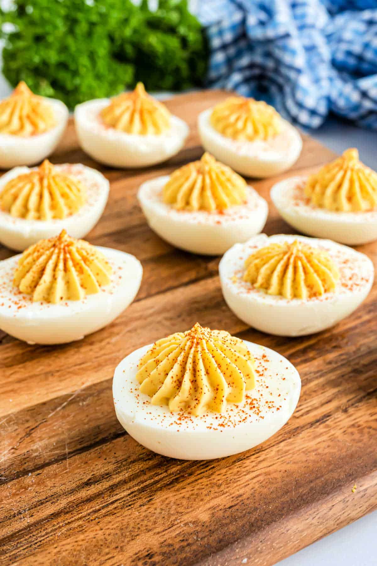 Deviled eggs on a wooden serving tray.