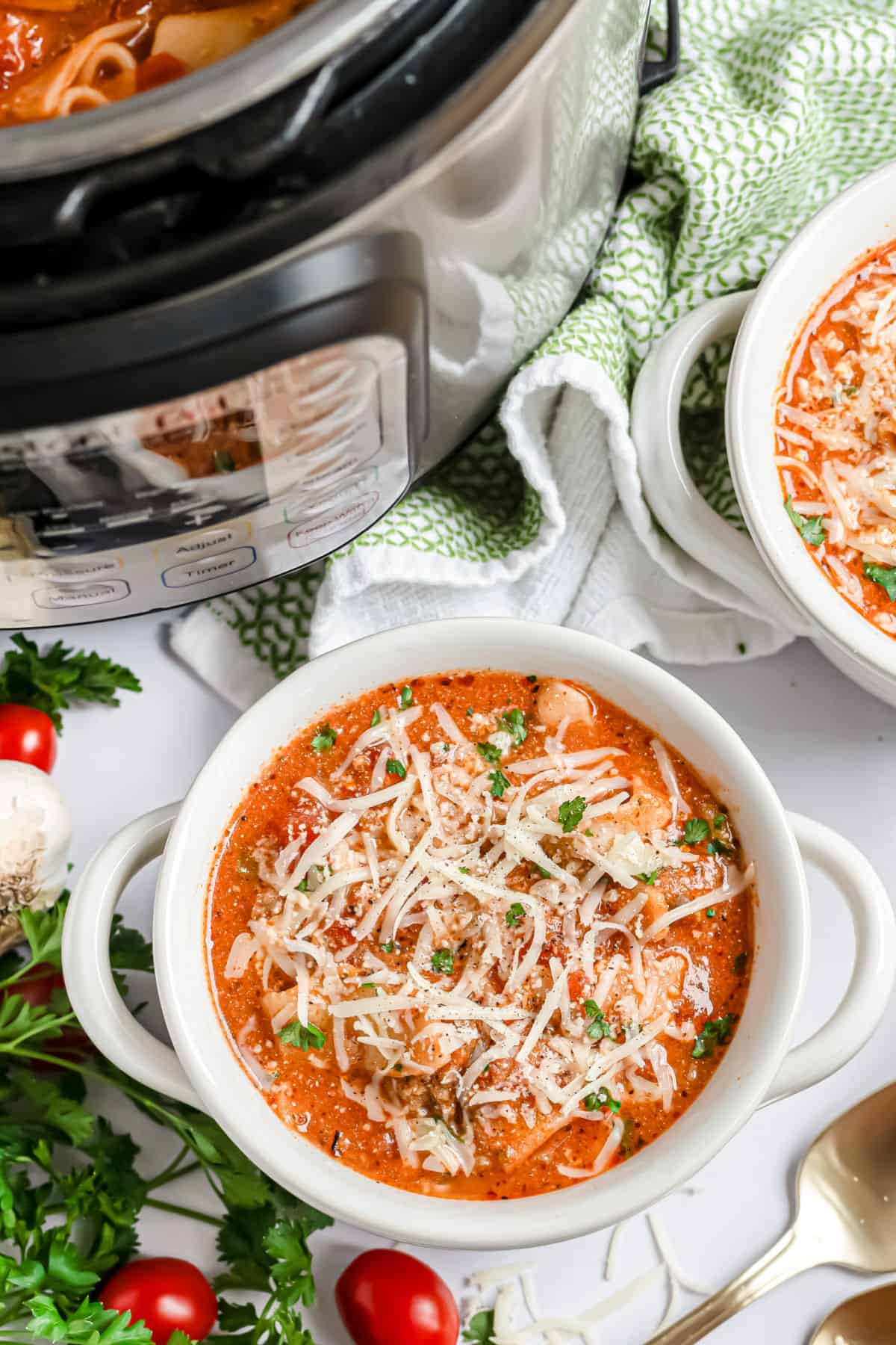 Lasagna soup served in a white bowl with handles.