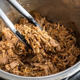 Fork tender pork served on a bun with coleslaw! This mouth watering, perfectly seasoned Instant Pot Pulled Pork recipe is just right for weeknight dinners or holiday parties!