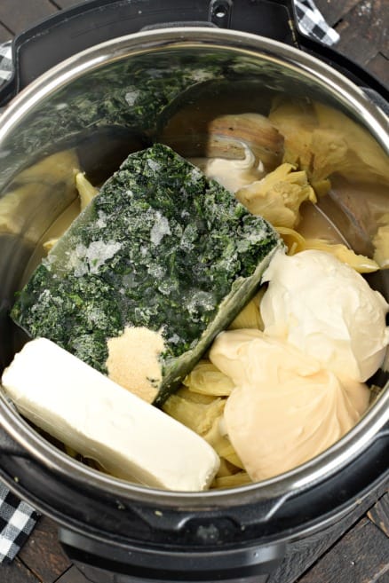 Ingredients in the Instant Pot for spinach artichoke dip.