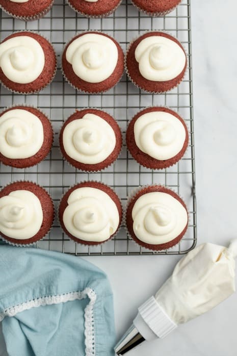 Red velvet cupcakes on a cooling rack.
