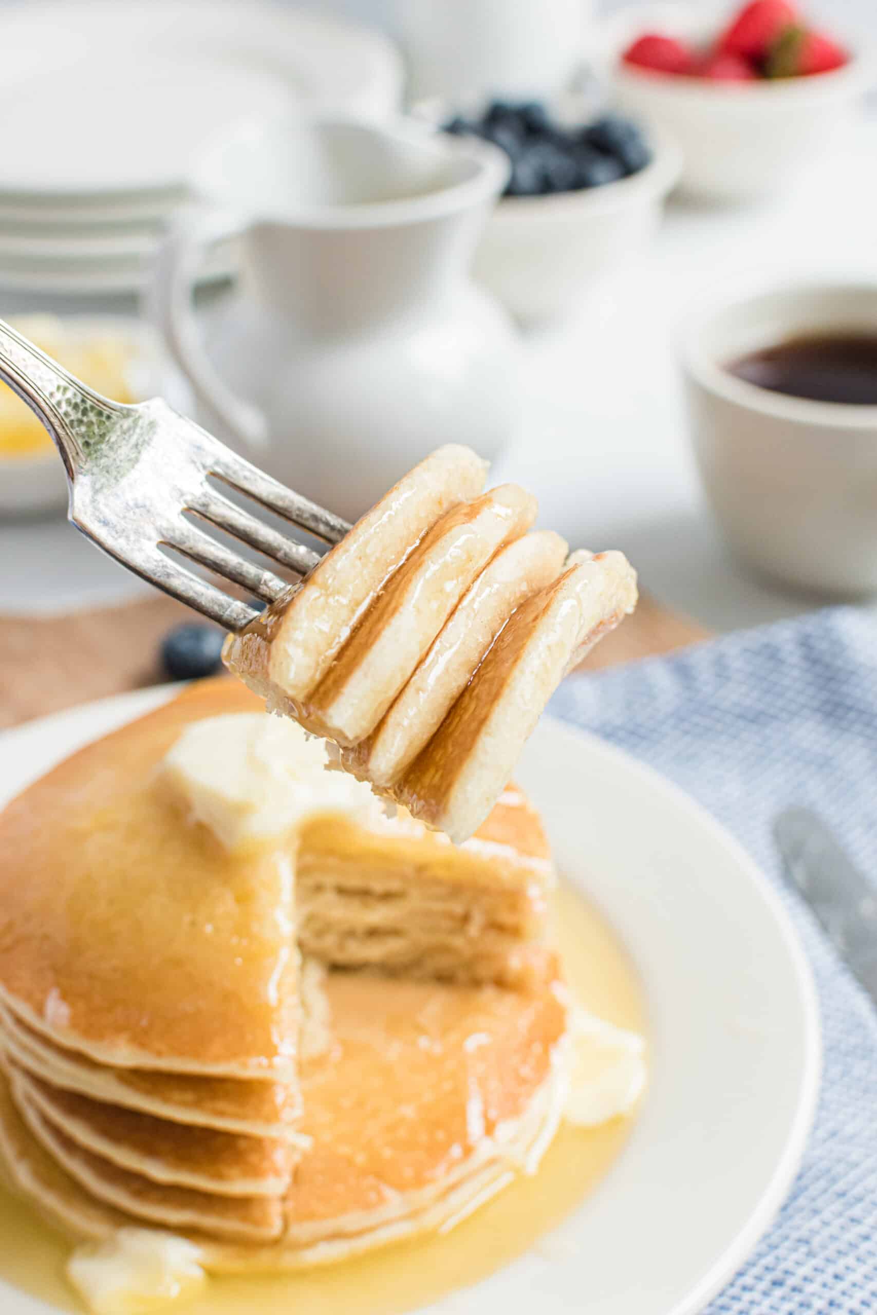 Stack of buttermilk pancakes with a forkful removed.