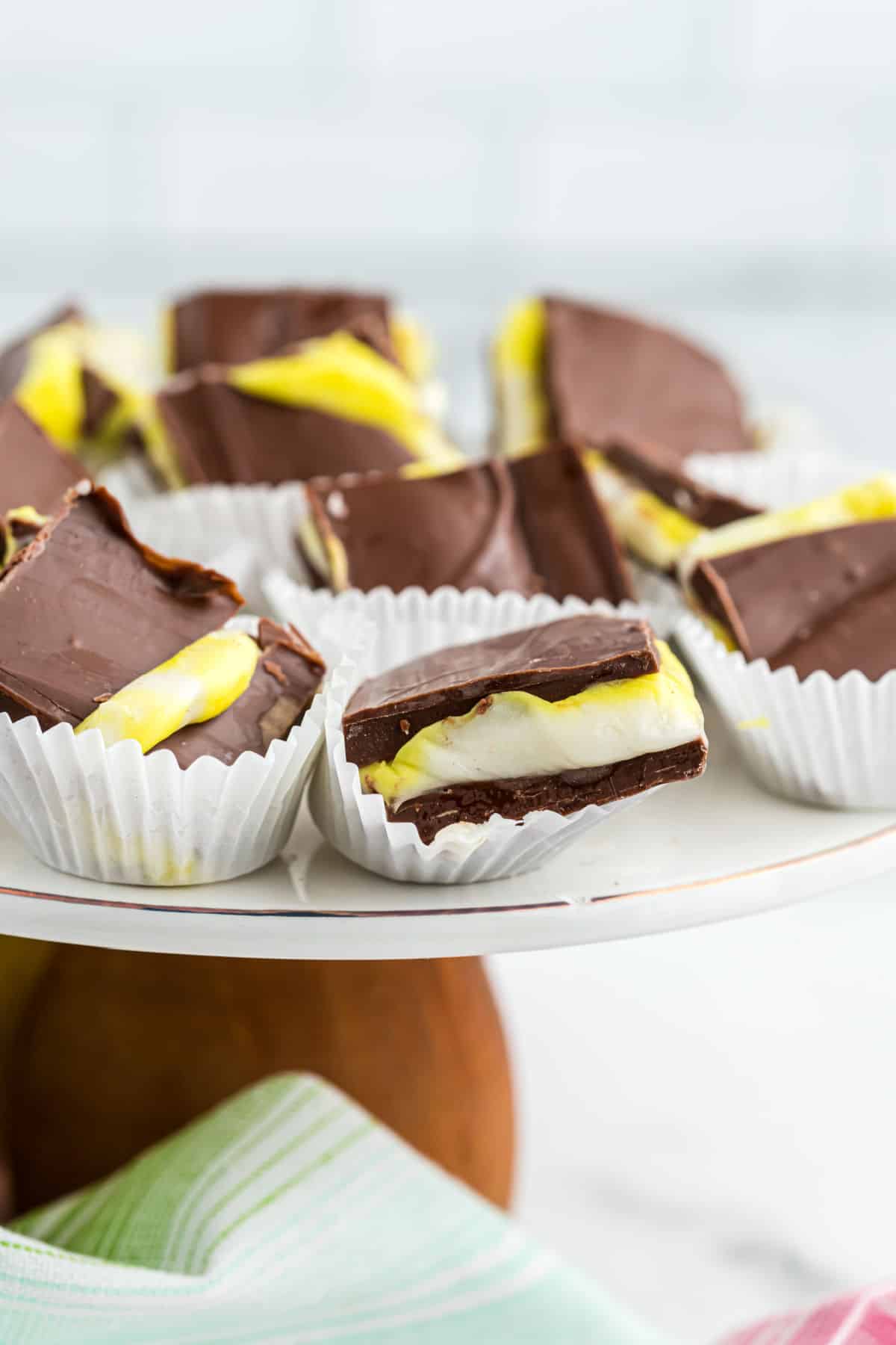 Cadbury egg fudge in paper cupcake liners on a cake server.