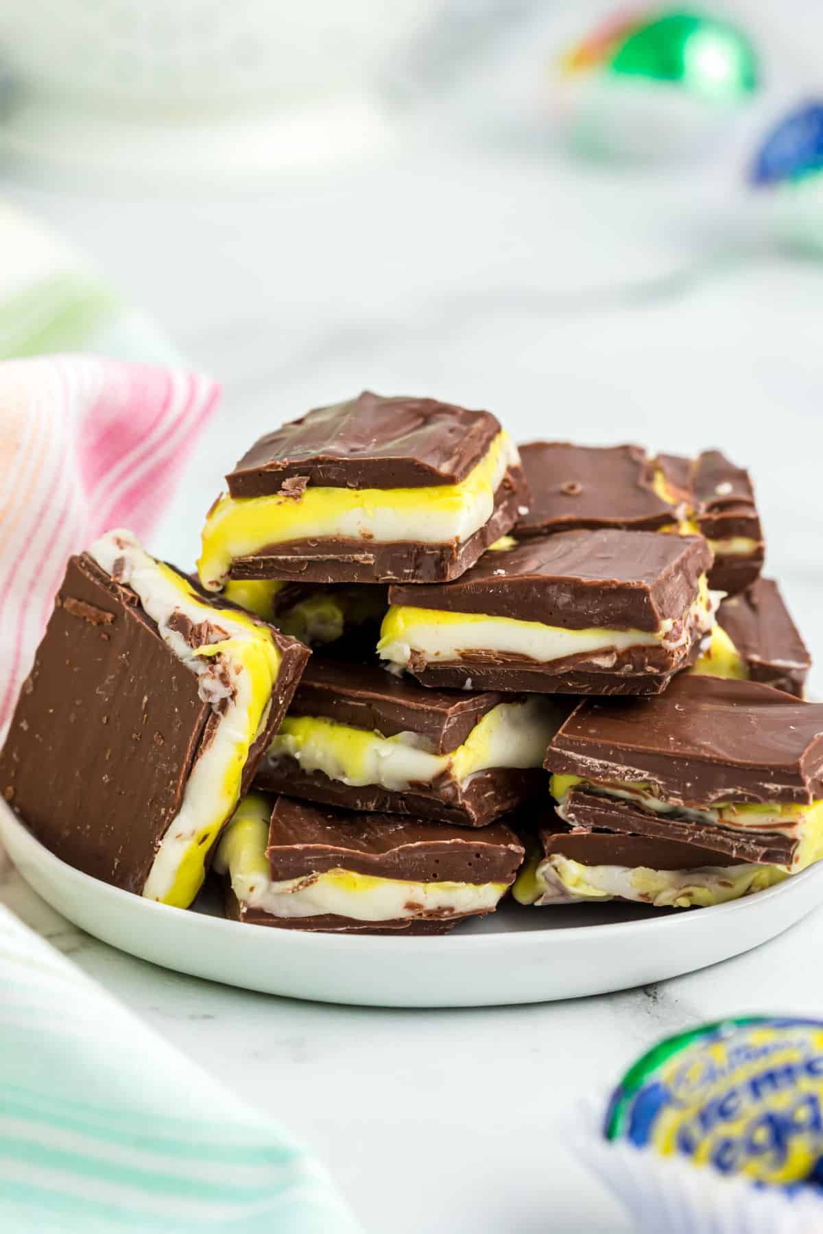 Cadbury egg fudge cut into squares on a white plate.