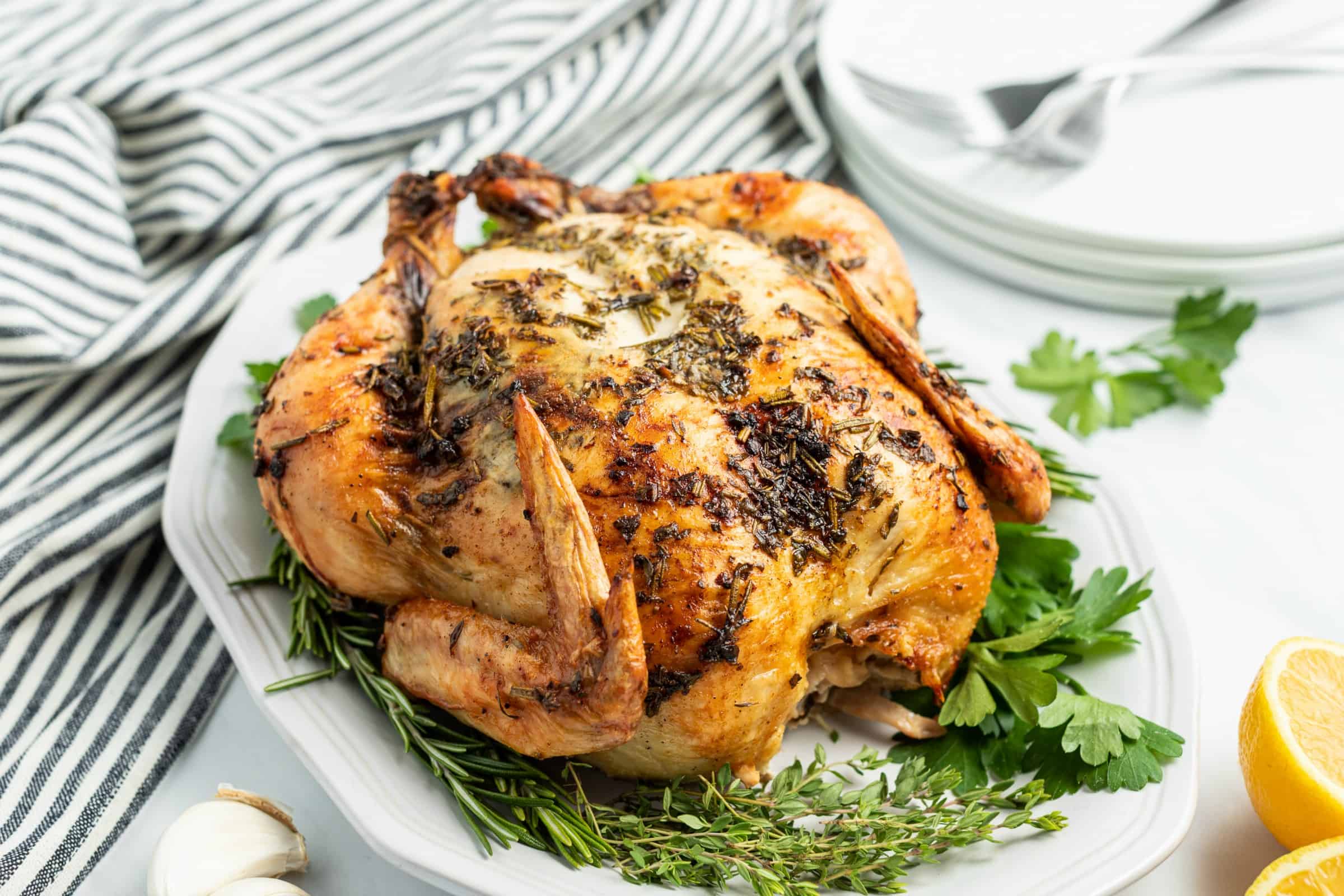 Whole chicken with garlic butter roasted on skin with fresh herbs.